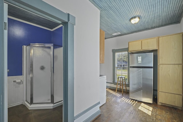 interior space with stainless steel refrigerator, dark wood-type flooring, crown molding, light brown cabinetry, and wood ceiling