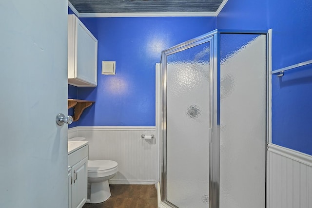 bathroom featuring vanity, a shower with door, crown molding, wood-type flooring, and toilet