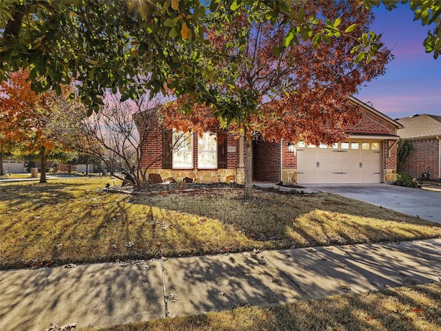 view of property hidden behind natural elements featuring a lawn and a garage