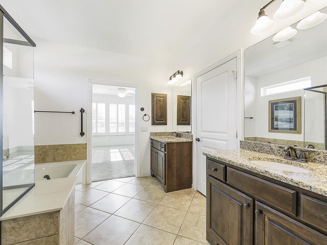 bathroom with tile patterned floors, vanity, ceiling fan, and a tub