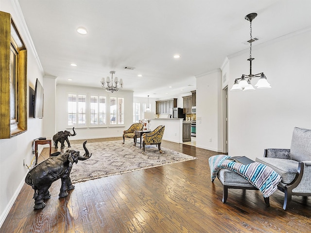 living room with ornamental molding, dark wood-type flooring, and an inviting chandelier