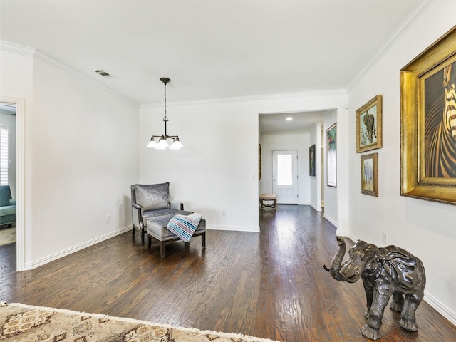 sitting room with a notable chandelier, dark hardwood / wood-style floors, and crown molding