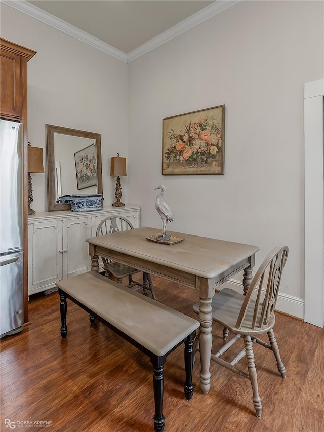 dining space with ornamental molding, wood finished floors, and baseboards