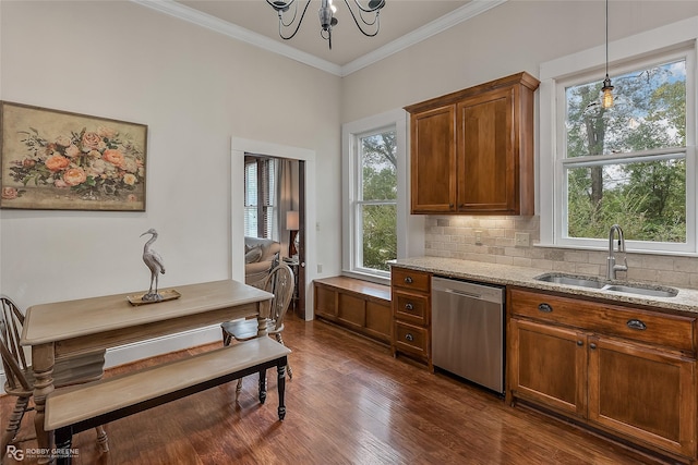 kitchen with light stone counters, crown molding, tasteful backsplash, stainless steel dishwasher, and a sink