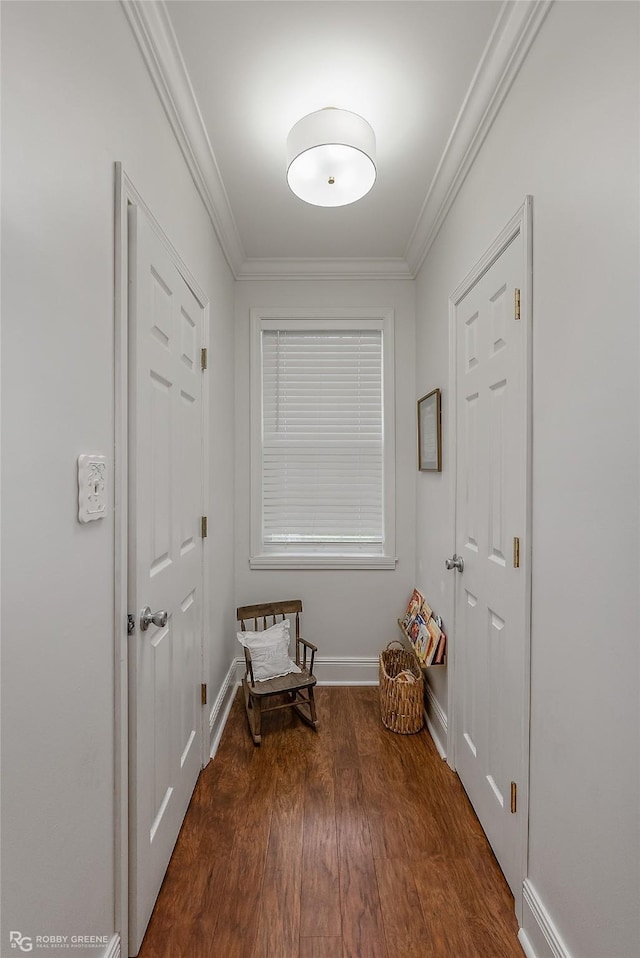 interior space featuring baseboards, wood finished floors, and crown molding