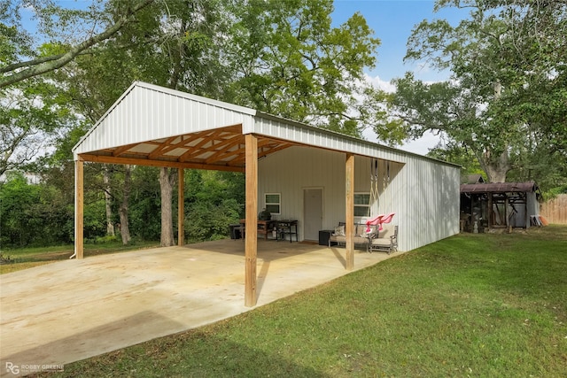 view of pole building with driveway, a carport, and a yard