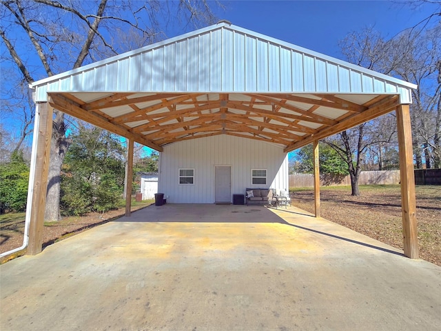 view of car parking with concrete driveway and fence