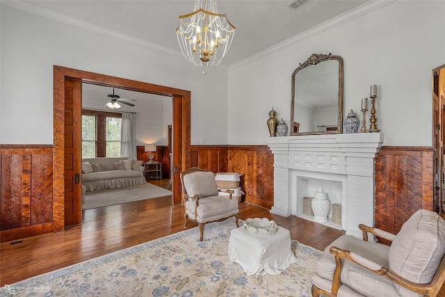 living area featuring a wainscoted wall, ornamental molding, and wood finished floors