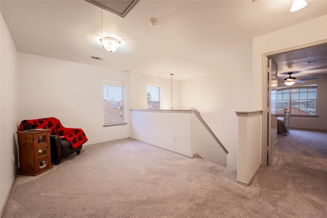 interior space with carpet flooring, a textured ceiling, a wealth of natural light, and ceiling fan