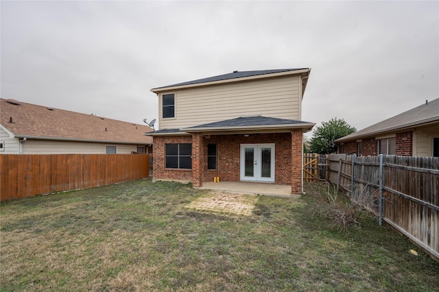 rear view of house featuring french doors, a patio, and a lawn