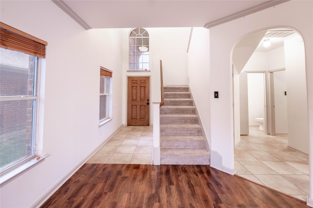 entryway featuring a healthy amount of sunlight, wood-type flooring, and ornamental molding