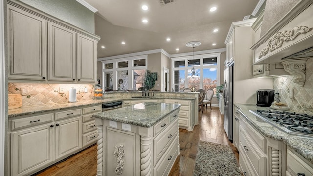 kitchen featuring light stone counters, appliances with stainless steel finishes, kitchen peninsula, and hanging light fixtures