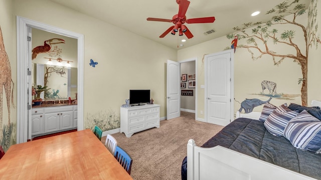 carpeted bedroom with ceiling fan and ensuite bath