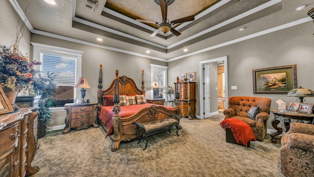 bedroom with a tray ceiling, ornamental molding, ceiling fan, and carpet flooring