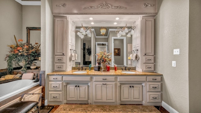 bathroom featuring a relaxing tiled tub, ornamental molding, and vanity