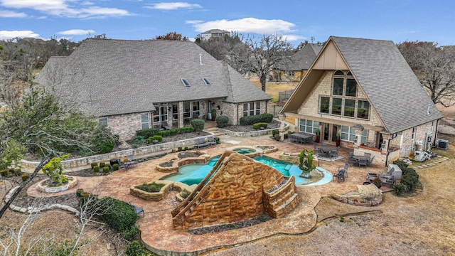 view of swimming pool featuring an in ground hot tub, central AC, and a patio area