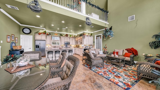 living room featuring a high ceiling and crown molding