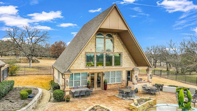 rear view of house with a patio, a fireplace, and french doors