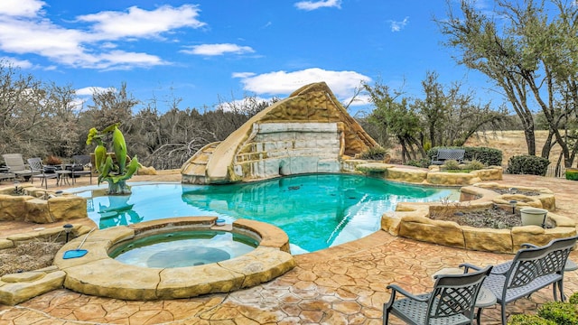 view of swimming pool with a patio area and an in ground hot tub