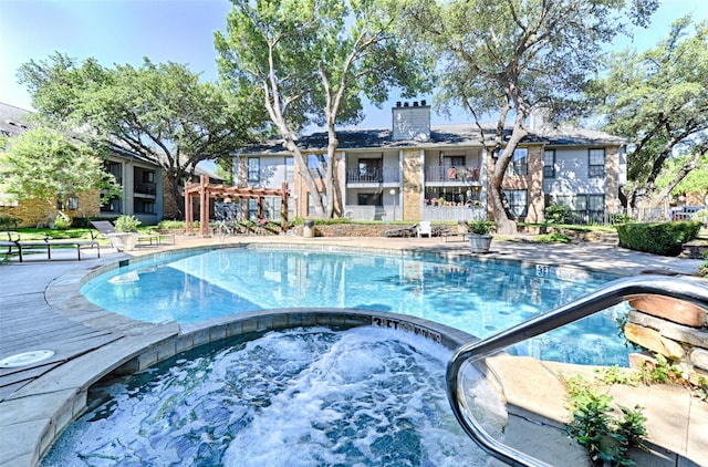 view of swimming pool with a community hot tub