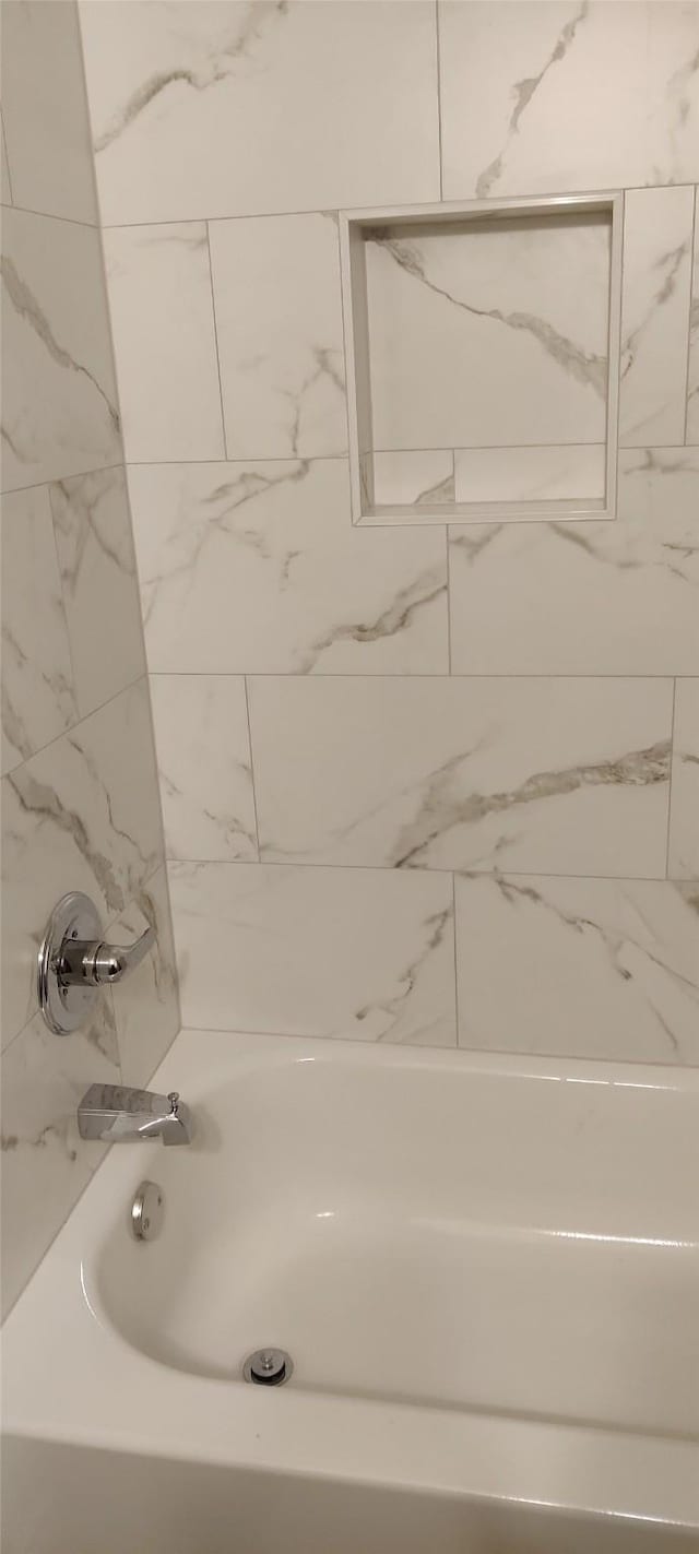 bathroom with tiled shower / bath combo