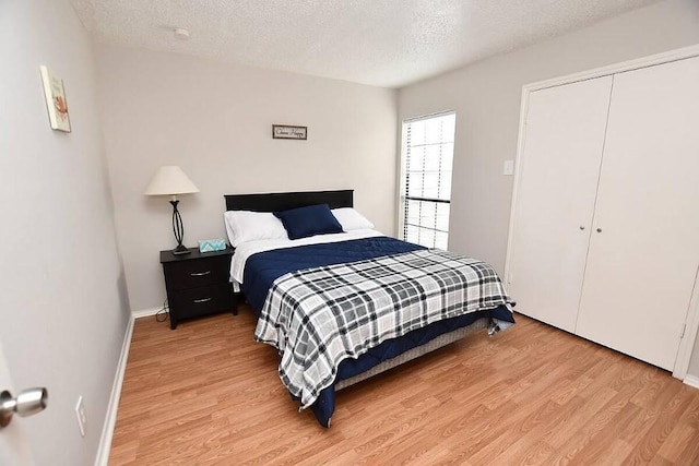 bedroom with hardwood / wood-style floors, a closet, and a textured ceiling