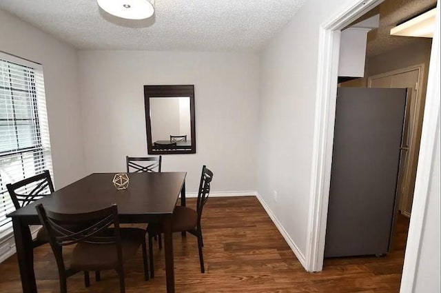 dining space featuring dark hardwood / wood-style floors and a textured ceiling