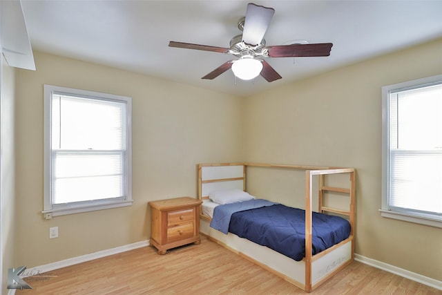 bedroom with light hardwood / wood-style floors, multiple windows, and ceiling fan