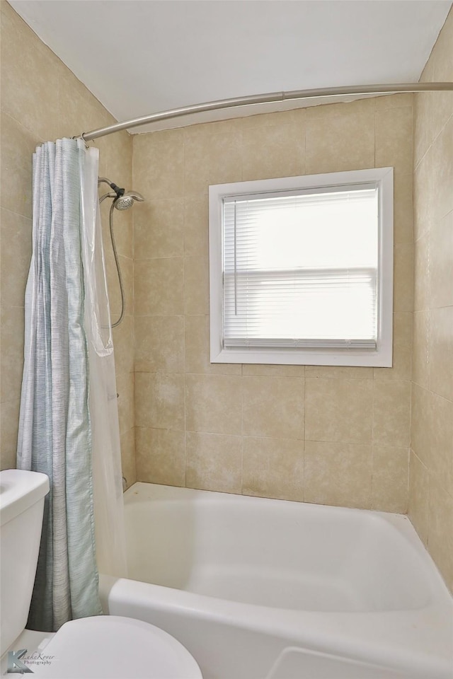 bathroom featuring toilet and shower / tub combo with curtain