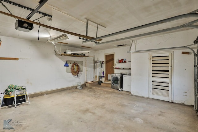 garage with washing machine and clothes dryer and a garage door opener