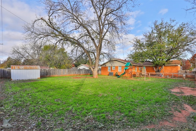 view of yard featuring a storage unit and a playground