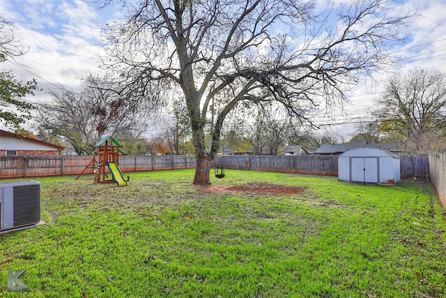 view of yard featuring cooling unit, a shed, and a playground