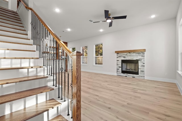 unfurnished living room featuring ceiling fan, a fireplace, and light hardwood / wood-style floors