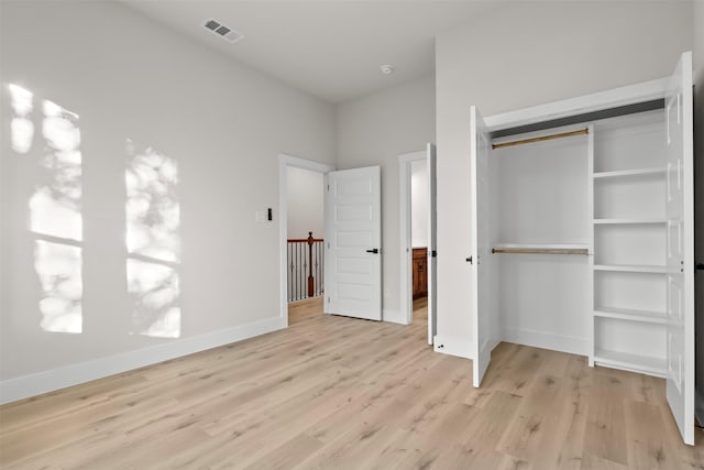 unfurnished bedroom with a closet and light hardwood / wood-style flooring