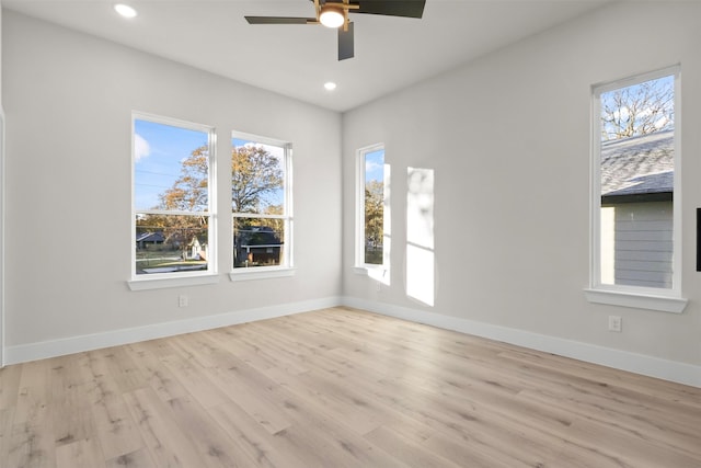 spare room featuring a wealth of natural light, ceiling fan, and light hardwood / wood-style flooring