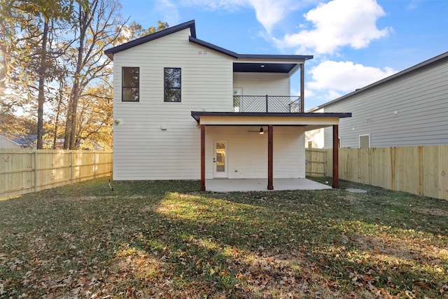 back of property featuring a balcony, a lawn, ceiling fan, and a patio area