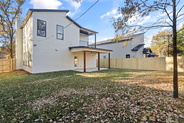 rear view of house with a yard and a patio area