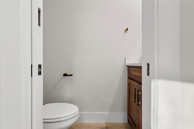 bathroom featuring hardwood / wood-style flooring, vanity, and toilet