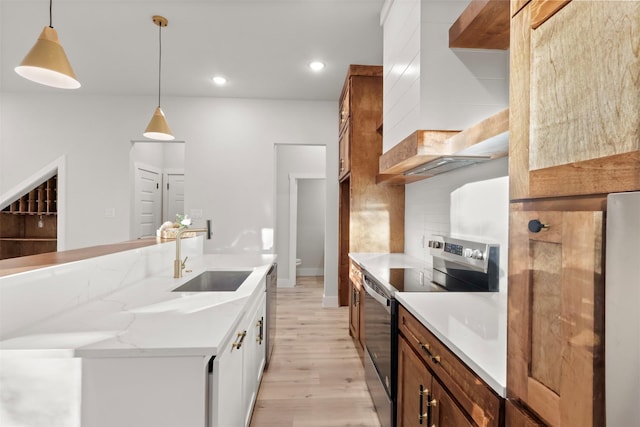 kitchen with appliances with stainless steel finishes, sink, decorative backsplash, hanging light fixtures, and light wood-type flooring