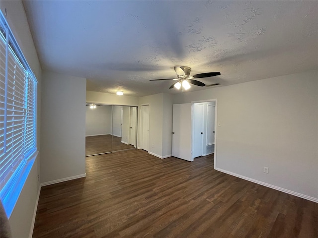 empty room featuring ceiling fan, dark hardwood / wood-style flooring, and a textured ceiling