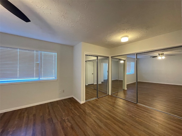 unfurnished bedroom featuring a textured ceiling, dark hardwood / wood-style flooring, and ceiling fan