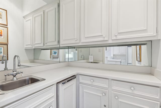 kitchen featuring white cabinets, sink, and white dishwasher