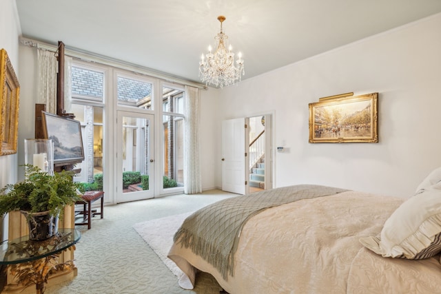 carpeted bedroom featuring access to outside and an inviting chandelier