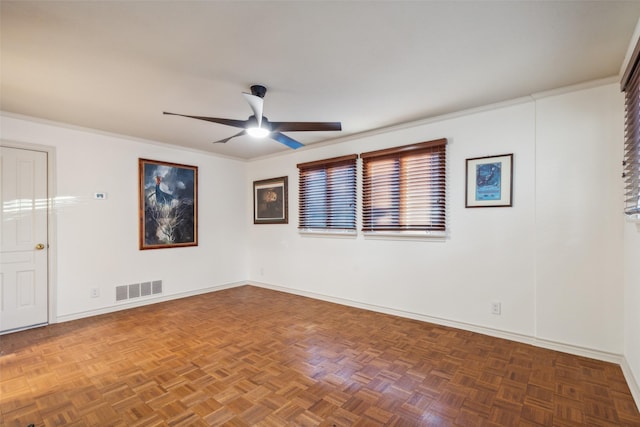 unfurnished room featuring dark parquet flooring, ceiling fan, and ornamental molding