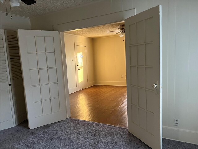 unfurnished room with ceiling fan, wood-type flooring, and a textured ceiling