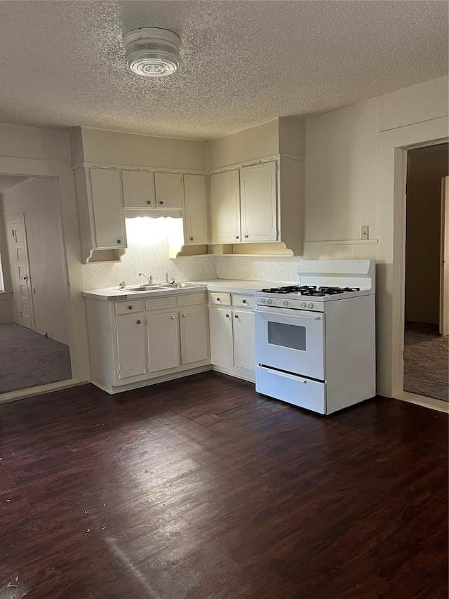 kitchen featuring white cabinets, dark hardwood / wood-style flooring, and gas range gas stove