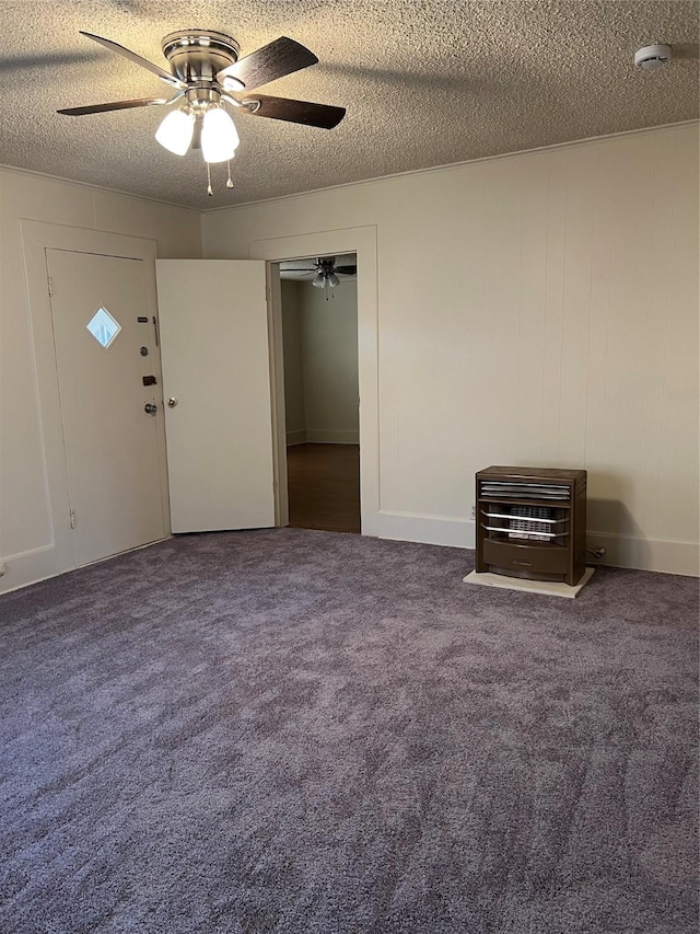 carpeted empty room with ceiling fan, a textured ceiling, and heating unit