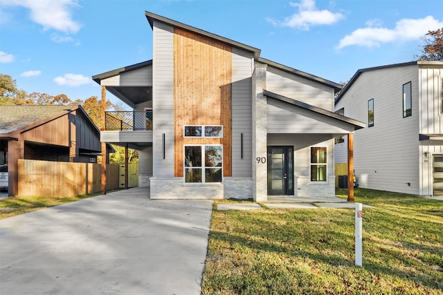 modern home with a balcony and a front yard