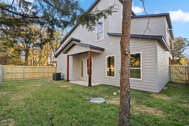 rear view of house with a yard, a patio, and central AC unit