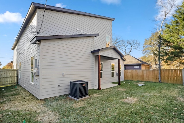 rear view of property featuring a lawn and central AC